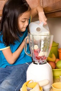 A kid making a smoothie