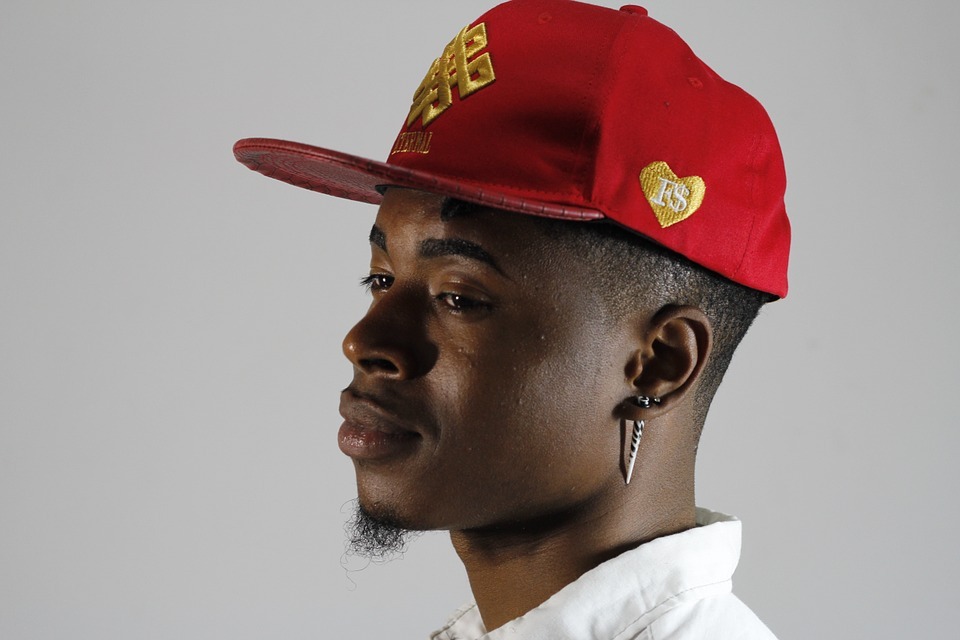 a man wearing a red flat-brimmed rapper hat