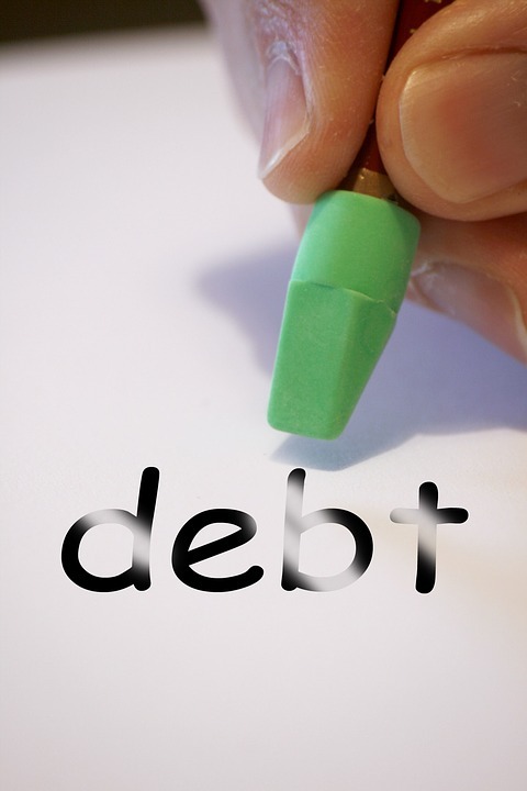 a person trying to erase the word debt with an eraser