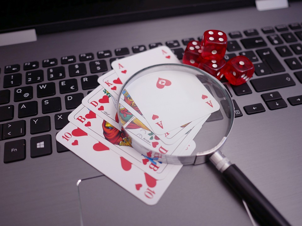 poker chips and dice on top of a laptop