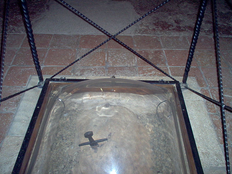 a sword stuck in a rock, encased inside a glass