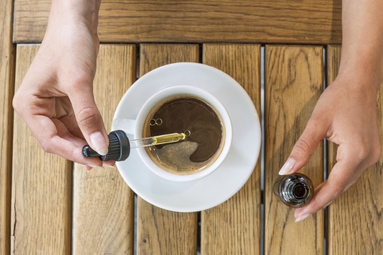 CBD oil being dropped into coffee
