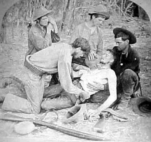 20th Kansas Volunteers attend to a wounded comrade. [Photo was taken in 1899, somewhere in Central Luzon]