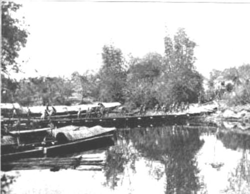 US troops taking guns across the Bigaa River on the bridge constructed by their engineering battalion