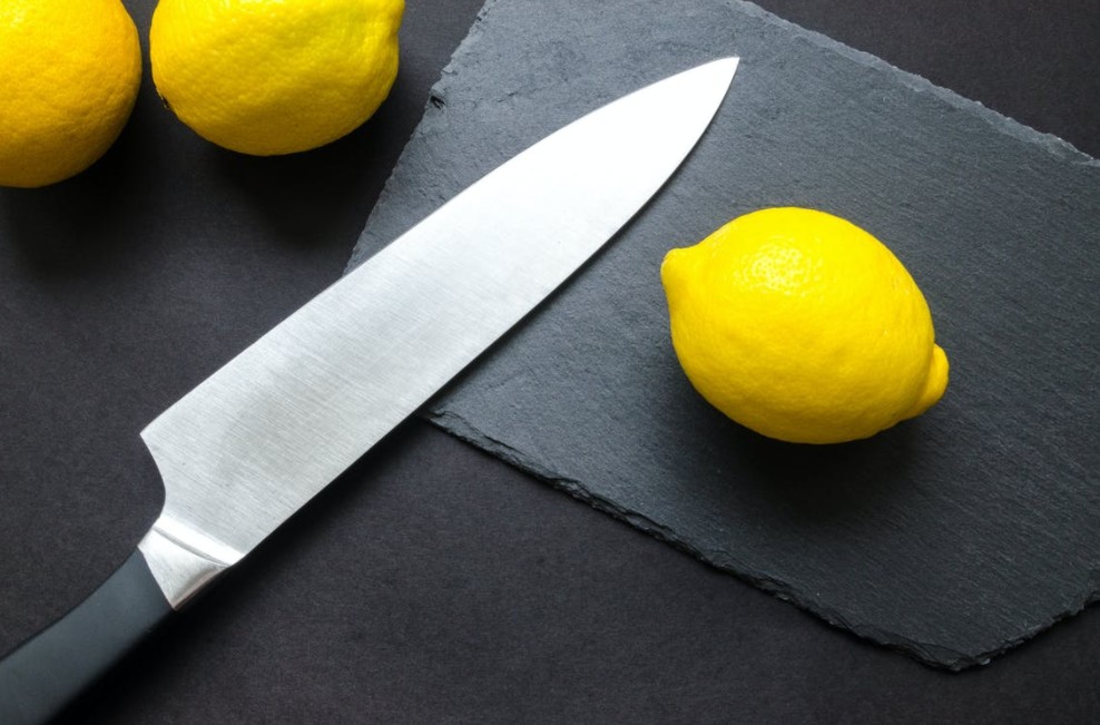a kitchen knife with some lemons