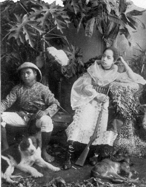 Filipina mestiza with rifle, a man and a dog