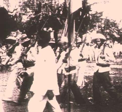 Filipino soldiers marching with flag