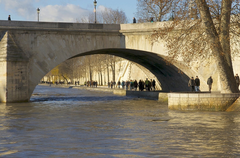people walking under the bridge in Paris