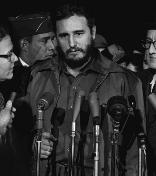 Fidel Castro with microphones in front of him during a news interview