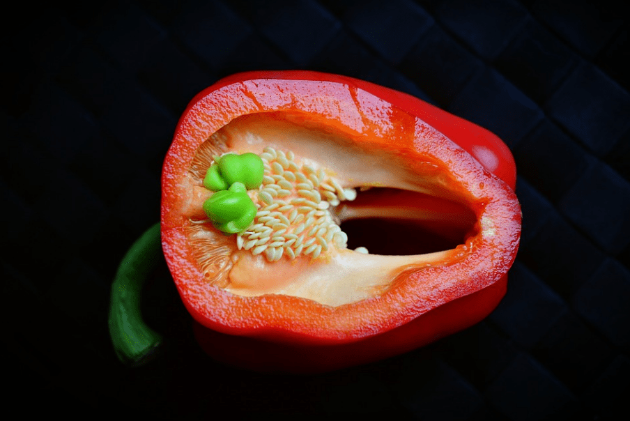 a halved bell pepper with seeds showing