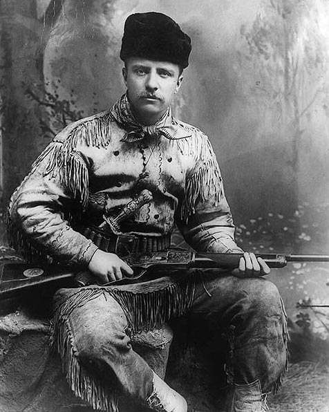 Theodore Roosevelt in hunting suit, and carved Tiffany hunting knife and rifle, 1885