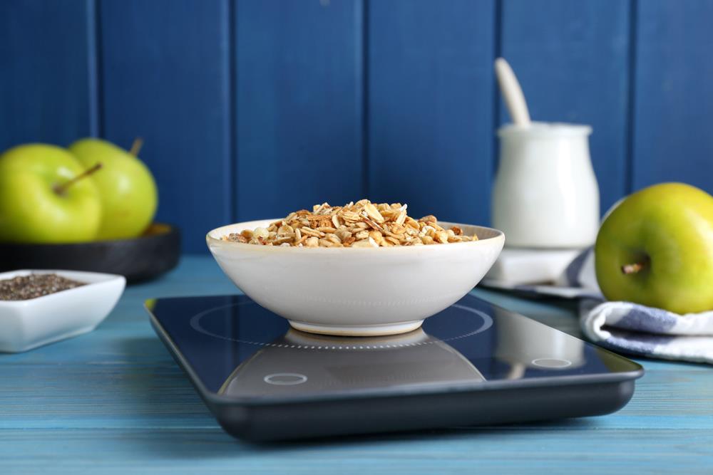 A bowl of granola on a weighing scale