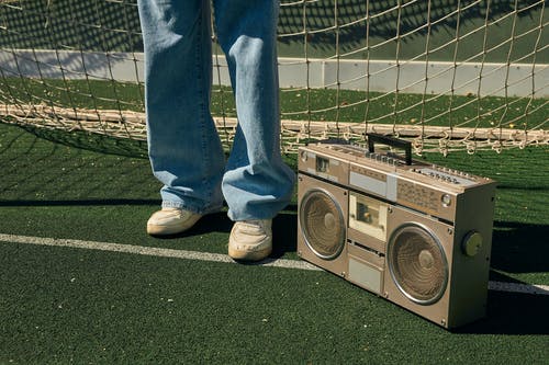 A person standing with a vintage boom box