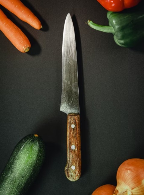 Kitchen knife with vegetables aside