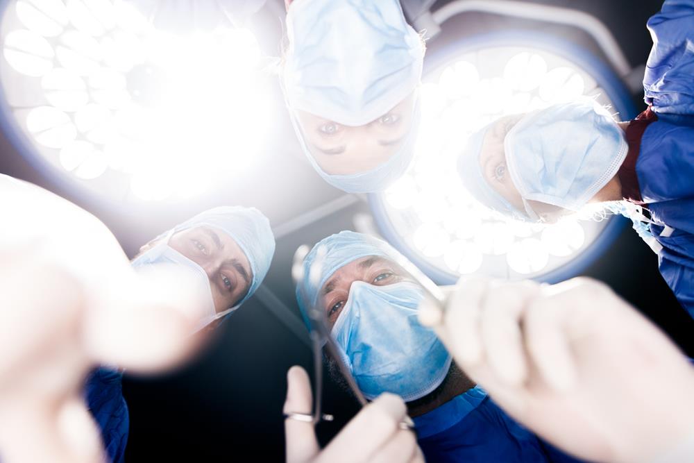 Surgeons under surgery lights in operating theater