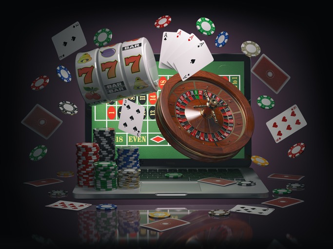 Online casino concept. Laptop roulette, slot machine, chips and cards