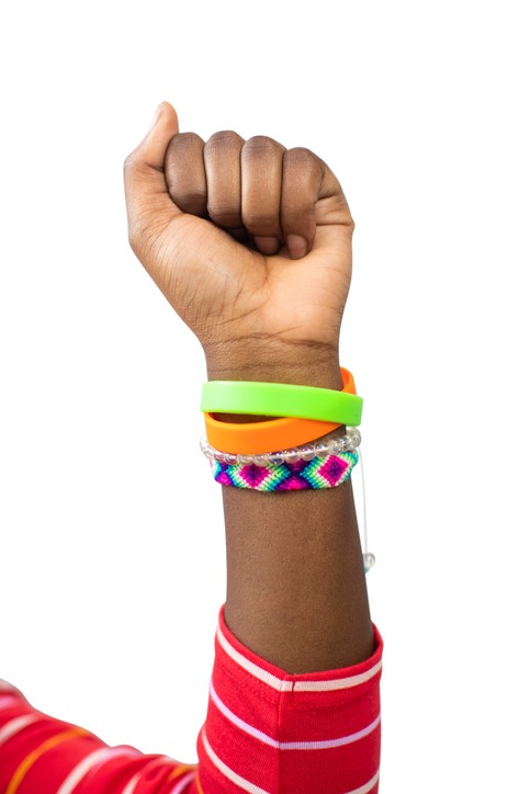 Close Up Of Teenage Girl Wearing Wristbands Raising Arm In Air To Depict Empowerment