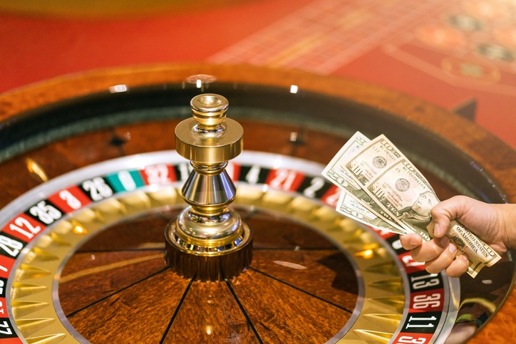 hand hold money bill bet at roulette wheel at casino club gambling game ideas concept