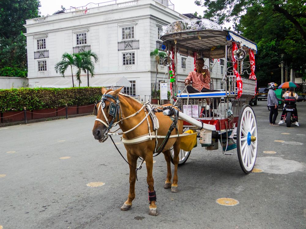 Picturesque street in the old town in Manila with a horse carriage