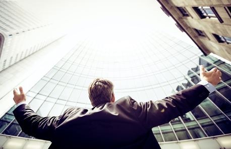 A businessman holding his arms up to the sky.